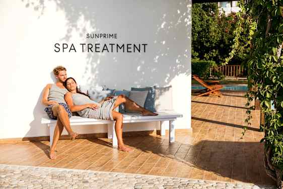 Man and woman relaxing on bench under spa sign on wall
