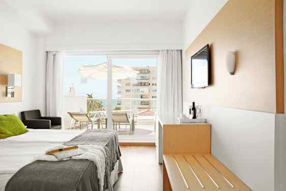 Hotelroom bed and kitchenett in green and beige nuances