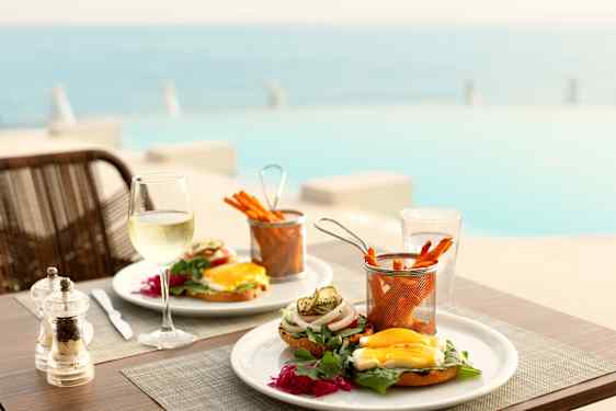 Burgers and sweetpotato fries on table by the pool