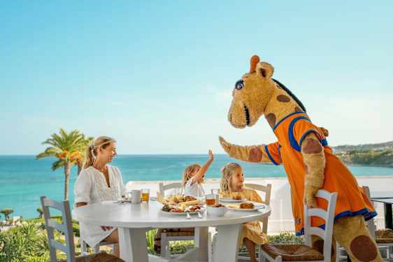 Children and woman at breakfast table and high fiveing with Lollo