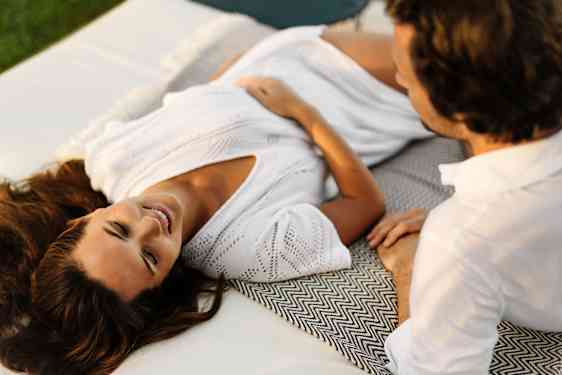 Woman and man relaxing on sunbed
