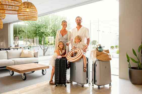 Family in lobby with suitcases
