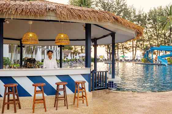 Waitress pouring sparkling wine into glass at bar