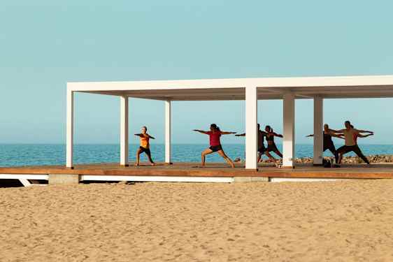 Yoga class in pavillion at the beach