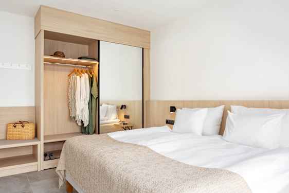 Ljust hotellrum med soffa och soffbord och utsikt över strand och hav