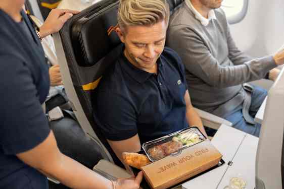 Flygvärdinna serverar mat ombord Sunclass Airlines