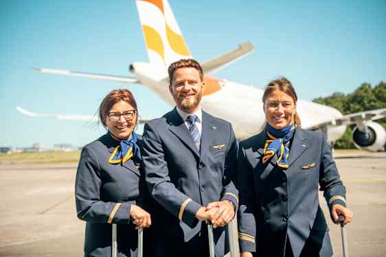 Two woman and one man in the middle, staff from Sunclass Airlines