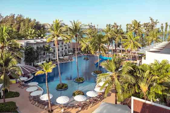 Pool surrounded by hotel buildings and palm trees