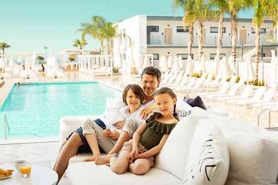 Family in lounge sofa by the pool