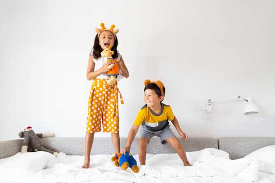 Girl and boy jumping in bed