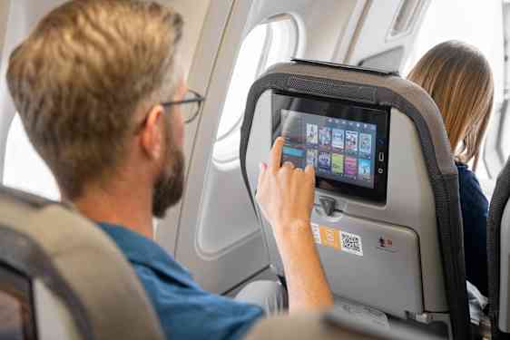 En mann gjennomsøker Sunclass Airlines underholdningssystem