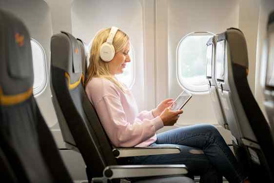 Kvinde med øretelefoner hos Sunclass Airlines 