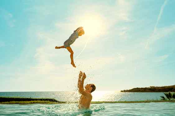 Dad and child playing in the pool