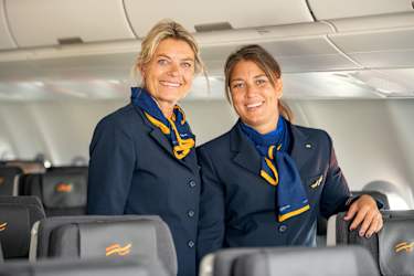 "To stewardesser står ombord på et fly"